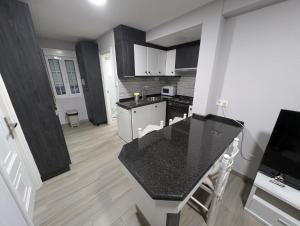 a kitchen with a black counter top in a room at Olladas de Laxe Apartamento con vistas in Laxe +5 photos