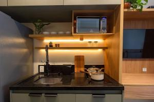 a kitchen with a sink and a microwave at Refúgio Moderno no Campo Belo NOVO in Sao Paulo