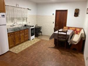 a kitchen with a sink and a table in it at Casa Planalto Gramado in Gramado