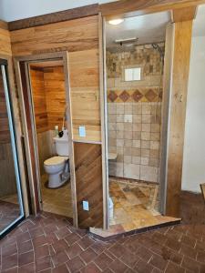 a bathroom with a toilet and a shower at GlampCamp in Big Arm +11 photos