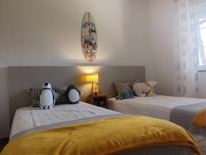 a bedroom with two beds with pillows on them at Apartamento em D'el Rey-Obidos Beach & Surf in Amoreira +19 photos
