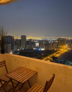 a bench and chairs on a balcony with a city skyline at Mens Luxury Room in Sharjah +2 photos