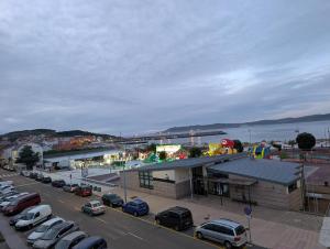 a parking lot with cars parked in front of a building at Olladas de Laxe Apartamento con vistas in Laxe
