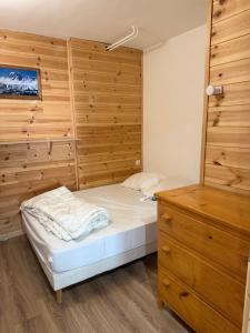 a bedroom with a bed and a wooden wall at magnifique duplex 8 couchages in Vars