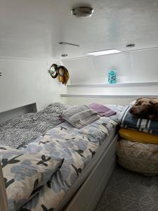 a bedroom with a bed and a clock on the wall at London Dutch Barge - Sleeps 3 & Cosy Fireplace in London