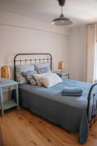 a bedroom with a bed with two chairs and two tables at Charmant appartement, calme, climatisé, centre historique in Avignon