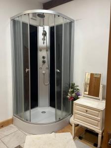 a shower with a glass enclosure next to a dresser at La villa Lambert-Longière in Monnai +26 photos