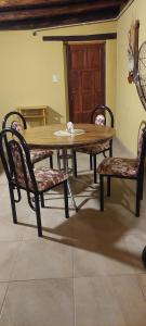 a wooden table and two chairs and a table and a door at Finca la margarita in Tinogasta