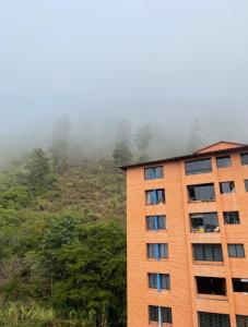 a tall building in front of a mountain at Magnífico Apartamento en Mérida in Mérida +5 photos