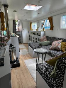 a living room with a couch and a table at London Dutch Barge - Sleeps 3 & Cosy Fireplace in London