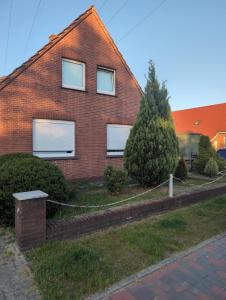 a red brick house with three windows on it at Obenende 38 in Papenburg