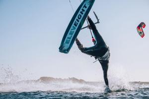 Un uomo è su una tavola nell'acqua di Dakhla kite Surf School & Lodge a Oulad Akkou