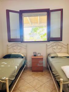 ガラティーナにあるCasa Vacanze Dimora Paradisoの窓が2つある部屋にベッドが2つある