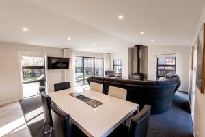 a living room with a table and a couch at Alpine | BBQ & Fireplace | Table Tennis - HS68319 in Hanmer Springs +10 photos