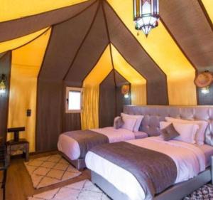 a bedroom with two beds in a room at lion Desert luxury Camp in Merzouga