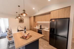 a kitchen with a black refrigerator and a counter at Alpine | BBQ & Fireplace | Table Tennis - HS68319 in Hanmer Springs