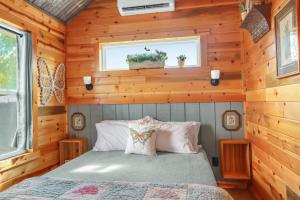 a bedroom with a bed in a wooden cabin at RusTx Ranch Unit 7- Music in Wimberley