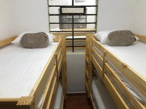 ベヨにあるEdificio cerca a Parque de Bello Antioquiaの窓付きの客室で、木製ベッド2台が備わります。 +72枚の写真