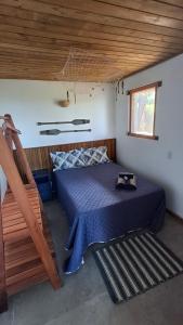 a bedroom with a bed and a wooden ceiling at Suíte Coqueiros Paraty in Paraty