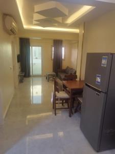 - un salon avec un réfrigérateur et une table dans l'établissement 68-5 2 BED ROOM -CRISS RESORT-NAAMA BAY -CITY CeNTER, à Charm el-Cheikh