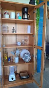 a wooden shelf with dishes and glasses on it at Suíte Coqueiros Paraty in Paraty +44 photos