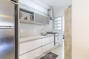 a kitchen with white cabinets and a stainless steel refrigerator at Apto c/ Churrasqueira em Cond. c/ Piscina BRI0102 in Florianópolis