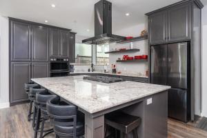 a kitchen with a large kitchen island with bar stools at Mariposa Grove Creekside Retreat in Fish Camp