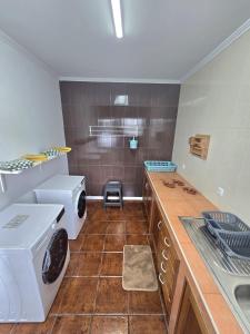 a kitchen with a sink and a washer and dryer at Lagoa Fabulous House in Lagoa +10 photos