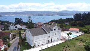a large white house with a view of the water at Naturmar in Raxó +37 photos