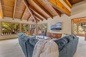 a large living room with a large couch and windows at Burning Tree in Flagstaff