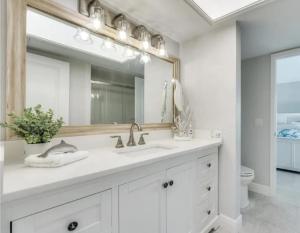 a bathroom with a sink and a mirror at Luxury Home with Deeded Private Beach Access Sanibel Island - 28 Day Stay Minumum in Sanibel +7 photos
