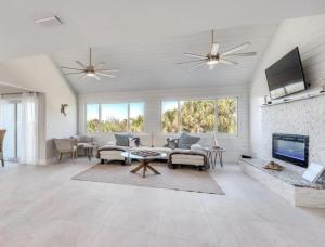 a living room with a couch and a tv at Luxury Home with Deeded Private Beach Access Sanibel Island - 28 Day Stay Minumum in Sanibel