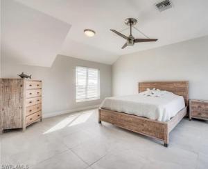 a bedroom with a bed and a ceiling fan at Luxury Home with Deeded Private Beach Access Sanibel Island - 28 Day Stay Minumum in Sanibel