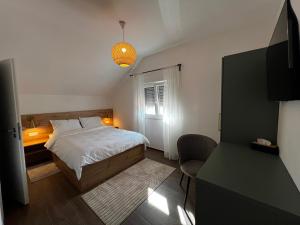 a small bedroom with a bed and a desk at BT Plitvice Holiday in Irinovac