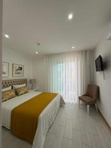 una camera da letto con un letto grande e una sedia di Santa Maria Residence - Central T2 a Santa Maria