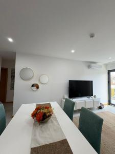 un soggiorno bianco con tavolo e TV di Santa Maria Residence - Central T2 a Santa Maria