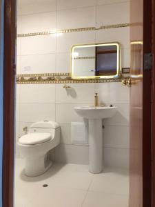 Un baño con lavabo, inodoro y espejo. en Hostel Sillustani Inn Puno, en Puno