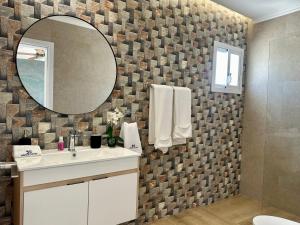 a bathroom with a sink and a mirror at Hotel Soficu Green Village  +16 photos