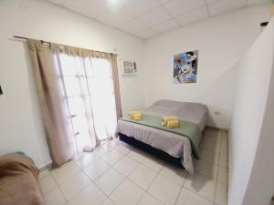 a bedroom with a bed and a large window at El Amanecer 7 12 in Charata