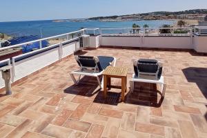 a patio with two chairs and a table on a balcony at Pis a primera línia de mar in L'Escala