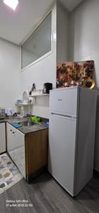 a kitchen with a white refrigerator and a sink at cosy home in Rabat