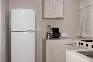 a kitchen with a white refrigerator and a blender at COLONIAL Suites in Ciudad Valles