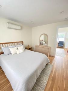 コー・ダレーンにあるModern, Quiet and Charming Downtown Apartmentの大きな白いベッドと鏡のある寝室