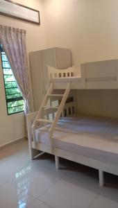 two bunk beds in a room with a window at Azzahra Homestay in Permatang Pauh