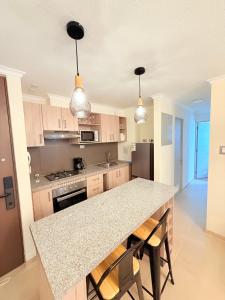 a kitchen with a granite counter top and a kitchen island at Departamento con piscina a pasos de la playa en La Serena in La Serena