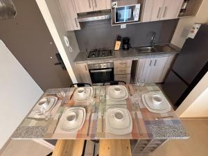 a kitchen with a table with four toilets in it at Departamento con piscina a pasos de la playa en La Serena in La Serena +29 photos
