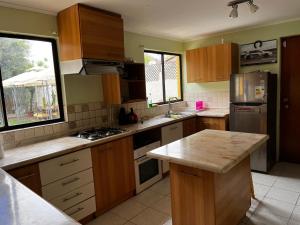 une cuisine avec des armoires en bois et un comptoir dans l'établissement Descanso y Trabajo en esta linda casa a pasos Casino ANTAY, à Copiapó