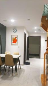 a dining room with a table and chairs and a clock at Great Deal Apartemen Grand Jati Junction Unit 1811 in Medan