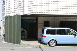 una furgoneta azul estacionada frente a un edificio en ATTA Toyosaki, en Osaka