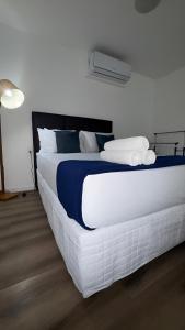 una camera da letto con un grande letto bianco con asciugamani sopra di Apto de luxo, requinte e lazer no coração de Belém a Belém